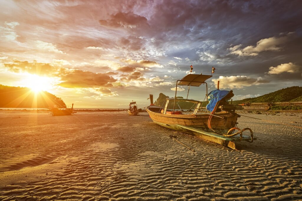 Long tail boat at beach on sunset